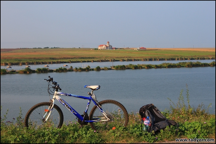 Bike and backpack by a lake and church
